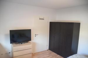 ein Schlafzimmer mit einem TV und einem Schrank mit einer Tür in der Unterkunft Ruhrbetten in Gelsenkirchen