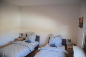 ein Schlafzimmer mit zwei Betten mit blauen Kissen in der Unterkunft Ruhrbetten in Gelsenkirchen