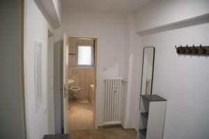 ein weißes Badezimmer mit Toilette und Spiegel in der Unterkunft Ruhrbetten in Gelsenkirchen