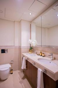 y baño con lavabo, aseo y espejo. en Magnificent 2 BR with Stunning Burj Khalifa View, en Dubái