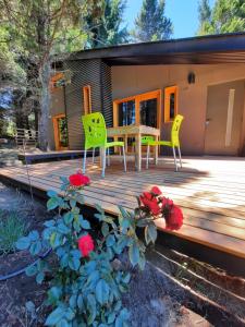 una terraza de madera con mesa y sillas en una casa en Orn, Chill Out Houses By A.M.A en San Carlos de Bariloche