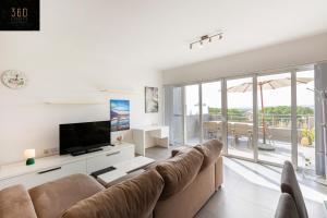 sala de estar con sofá y TV de pantalla plana en Sunny & beautiful views, Amazing Design & Terrace by 360 Estates, en Lija