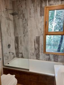 bagno con vasca e finestra di Orn, Chill Out Houses By A.M.A a San Carlos de Bariloche