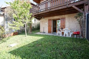 a patio with a table and chairs in a yard at Le Mont Guillaume - 1 chambre Terrasse et Jardin in Saint-André-dʼEmbrun