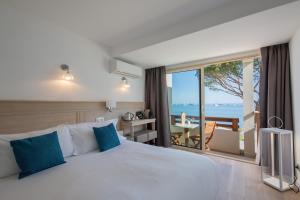 a bedroom with a bed with a view of the ocean at Hôtel La Roya in Saint-Florent +37 photos