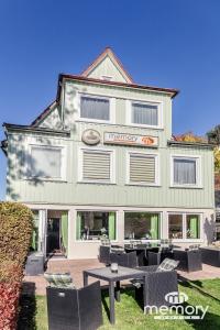 ブラウンラーゲにあるMemory Hotelの建物の前にテーブルと椅子