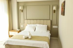 a bedroom with a bed with a stuffed animal on it at PETRA HOTEL TUZLA in Tuzla