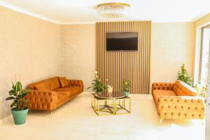 a living room with two couches and a tv at PETRA HOTEL TUZLA in Tuzla