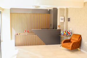 - un salon avec une chaise et un mur dans l'établissement PETRA HOTEL TUZLA, à Tuzla