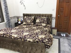 a bedroom with a large bed with a brown bedspread at C4 Mirpur City AJK Overseas Pakistanis Villa - Full Private House & Car Parking in New Mīrpur