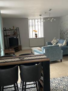 a living room with a couch and a table with chairs at Ulverston first floor apartment with roof terrace in Ulverston