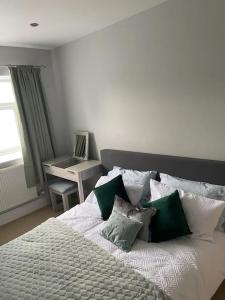 Schlafzimmer mit einem Bett mit grünen und weißen Kissen in der Unterkunft Ulverston first floor apartment with roof terrace in Ulverston