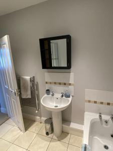 a bathroom with a sink and a mirror on the wall at Ulverston first floor apartment with roof terrace in Ulverston