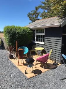 a group of chairs and tables on a patio at The Bay Cabin, secluded retreat Freshwater Bay in Freshwater