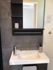 a white sink in a bathroom with a mirror at The Bay Cabin, secluded retreat Freshwater Bay in Freshwater