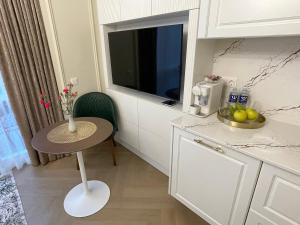 a small kitchen with a small table and a television at ART Uzupis Apartment in City center in Vilnius