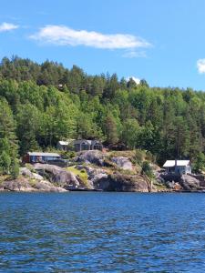 eine Gruppe von Häusern am Ufer eines Sees in der Unterkunft Perle ved sjøen! Ny hytte på 90m2. in Kragerø