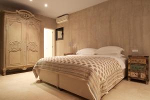 ein Schlafzimmer mit einem großen Bett und einem großen Schrank in der Unterkunft Exquisite Ibiza Villa I Secluded Hillside Location I Casa Jardin I 6 Bedrooms in San Jose de sa Talaia
