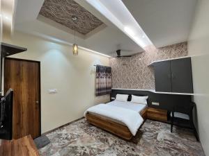 1 dormitorio con 1 cama y 1 silla en Hotel Aryadeep en Phardāpur