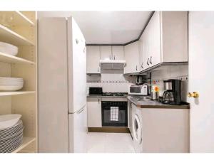 cocina con armarios blancos y lavavajillas en Apartamento en el centro de Madrid (chueca), en Madrid
