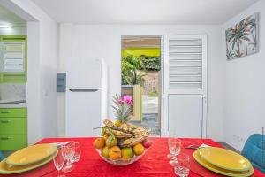 a table with a bowl of fruit on a red table cloth at Douceur Antilla apartment in Morne Blanc +12 photos