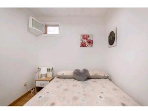 ein Schlafzimmer mit einem Bett mit einem Herzkissen drauf in der Unterkunft Apartamento en el centro de Madrid (chueca) in Madrid