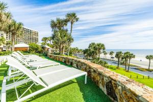 a row of white lounge chairs overlooking the beach at Gulf Overlook San Luis Resort 1035 in Galveston