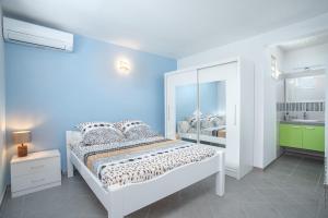 a bedroom with a white bed and a bathroom at Douceur Antilla apartment in Morne Blanc