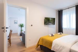 a bedroom with a bed with a yellow blanket at Design 2BDR Apartment with Balcony- FREE PARKING in Zagreb