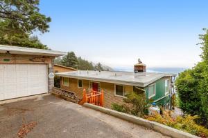 a house with a garage and the ocean in the background at The Nook on Chinook in Tillamook