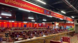 a large dining hall with tables and chairs and red walls at TM18 - 3 Bedroom Mobile Home Golden Palms Resort TV`s in Every Room Decking Indoor Heated Pool Entertainment complex & Close To Beaches PASSES NOT INCLUDED in Skegness