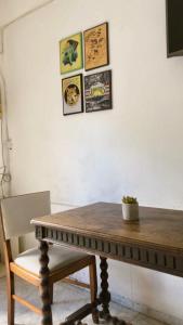einen Holztisch und einen Stuhl mit Bildern an der Wand in der Unterkunft Tajy - Monoambiente - Barrio Residencial in Corrientes