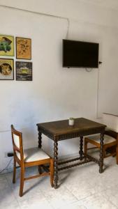 einen Tisch und einen Stuhl sowie einen TV an der Wand in der Unterkunft Tajy - Monoambiente - Barrio Residencial in Corrientes