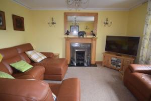 a living room with a couch and a television at Ulverston Centre Superb 3 Double Bedroom Apartment in Ulverston