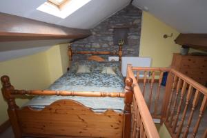 a wooden bed in a room with a staircase at Ulverston Centre Superb 3 Double Bedroom Apartment in Ulverston