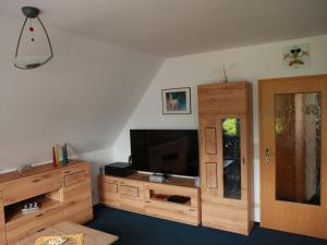 a living room with a tv and a wooden entertainment center at FW Lehmann in Zingst