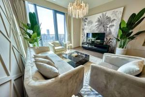 - un salon avec deux canapés et un lustre dans l'établissement Magnificent Lux 2 BR with Incredible Skyline View, à Dubaï