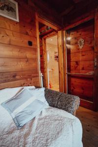 a bedroom with a bed in a room with wooden walls at chata u Tesáku in Rajnochovice