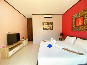 a hotel room with a bed and a tv at MA MAISON BOUTIQUE HOTEL. in PHUKET in Bang Tao Beach
