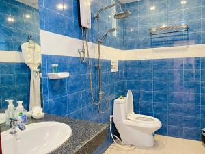 Baño de azulejos azules con aseo y lavamanos en MA MAISON BOUTIQUE HOTEL. in PHUKET, en Bang Tao Beach