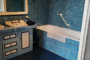 a blue tiled bathroom with a tub and a sink at Villa d'artiste comprenant 2 chambres avec salles de bain privatives in Arcachon +24 photos