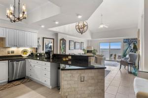 a kitchen with white cabinets and a large island at Nautical Club #702 in Atlantic Beach