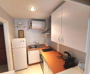 a small kitchen with a white refrigerator and orange counter top at Carlos Cañal in Seville