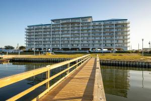 een groot gebouw met een houten steiger ervoor bij Nautical Club #702 in Atlantic Beach