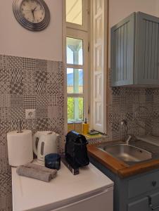 a kitchen with a sink and a clock on the wall at The Valkyries 3 in Leonidio