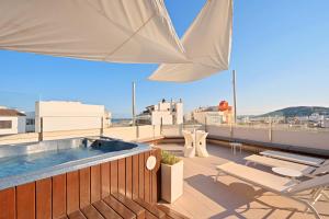 a rooftop deck with a swimming pool and an umbrella at Mar Calma Hotel in Port de Pollensa