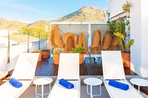 d'un balcon avec des tables blanches, des chaises et des plantes. dans l'établissement Mar Calma Hotel, à Port de Pollença