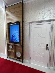 a room with a white door and a tv at E-lite& Meatador in Astana