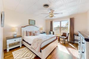 a bedroom with a bed and a ceiling fan at Suniland Cottage in Fredericksburg