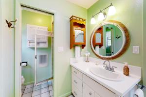 a bathroom with a sink and a mirror at Suniland Cottage in Fredericksburg +17 photos